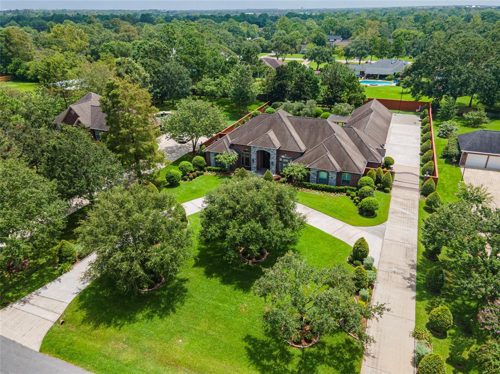 an aerial view of residential houses with outdoor space and trees