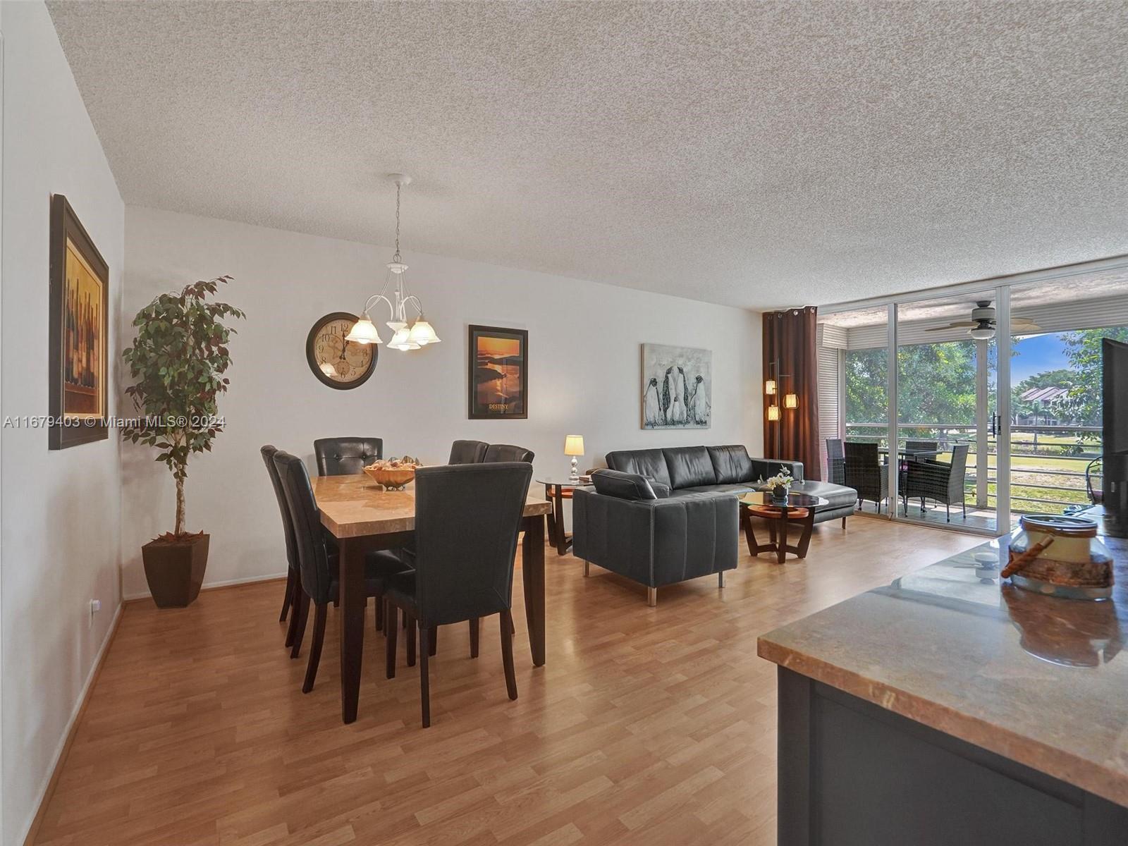 a view of a dining room and livingroom with furniture wooden floor and a rug