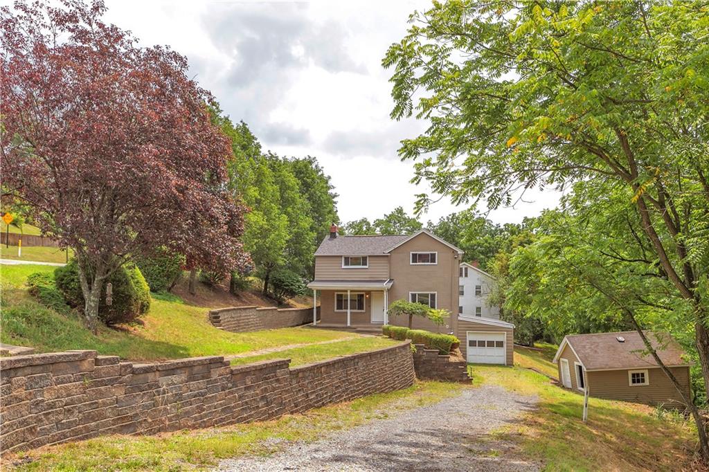 a aerial view of a house with a big yard and large trees