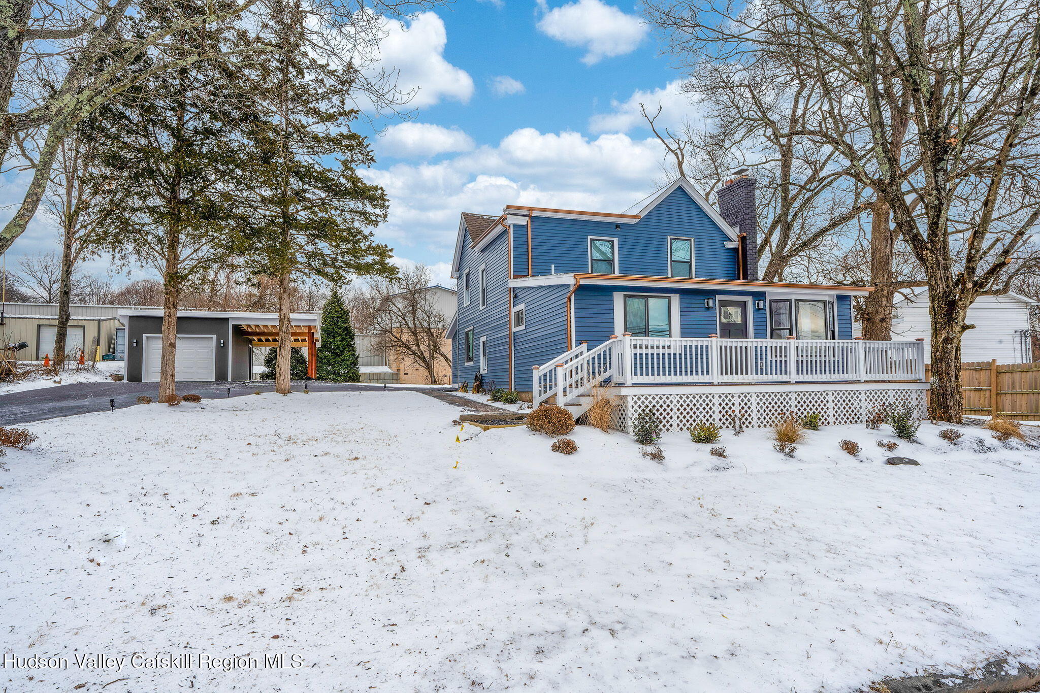 a view of a large white house with a yard covered with snow