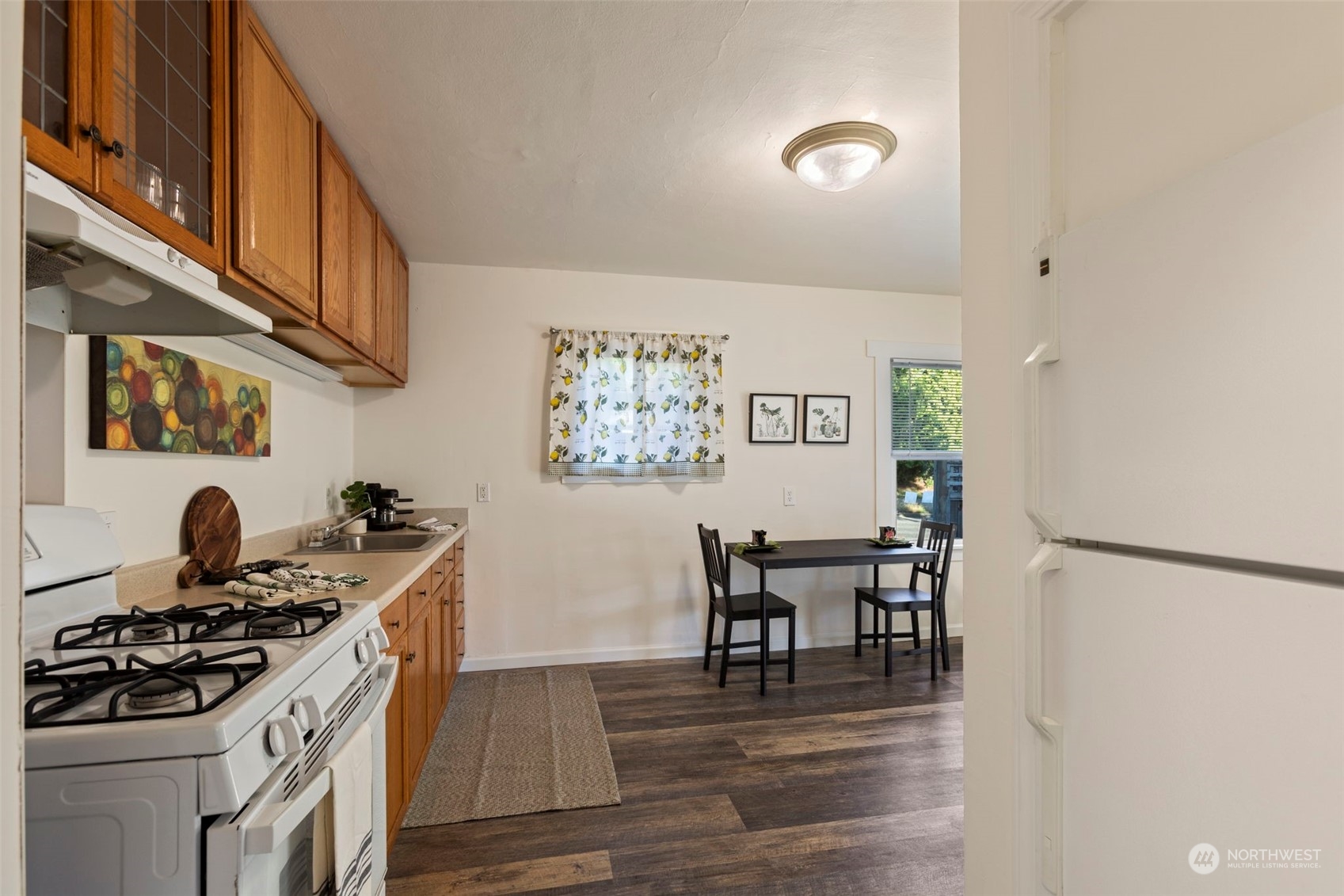 a kitchen with stainless steel appliances granite countertop a stove and a dining table with wooden floor