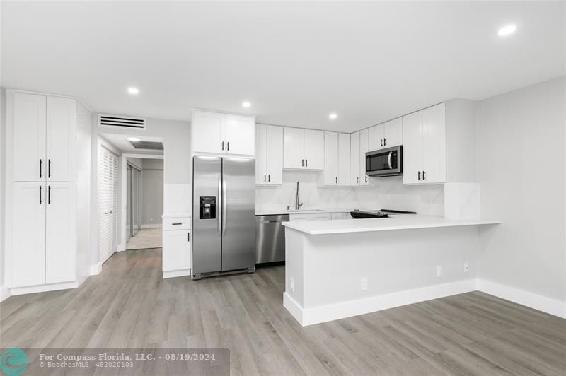 a kitchen with stainless steel appliances a refrigerator and a stove top oven