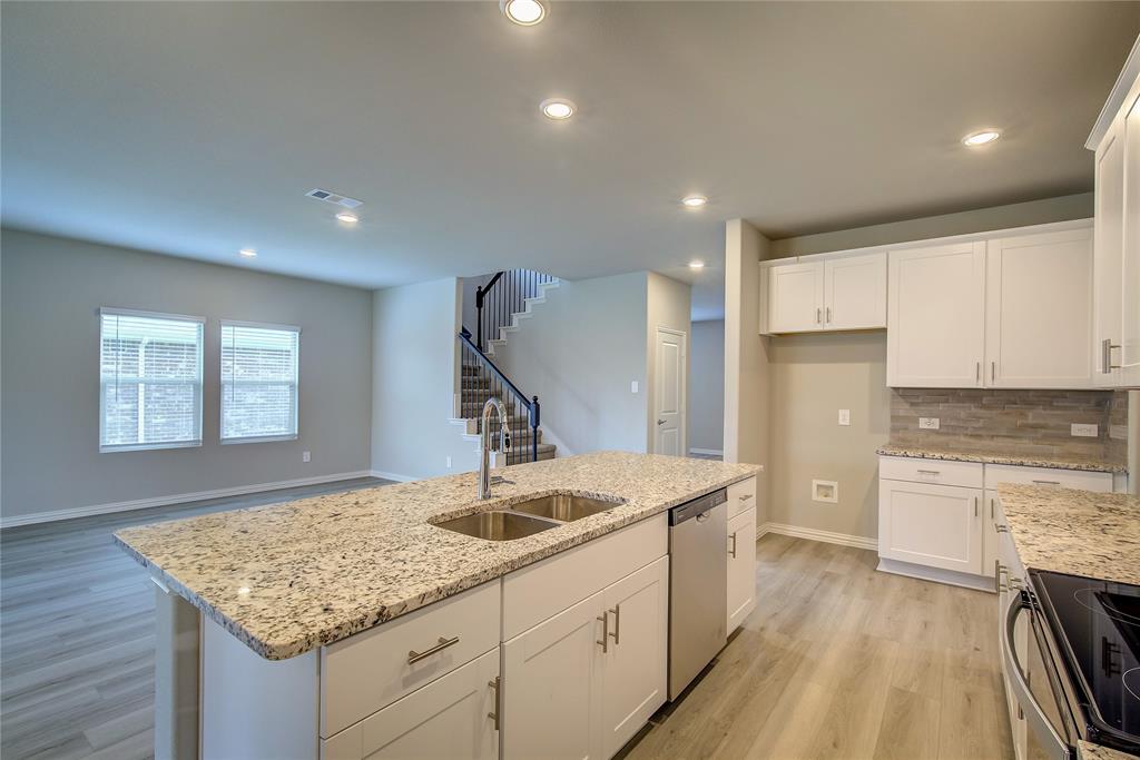 a kitchen with sink cabinets and wooden floor