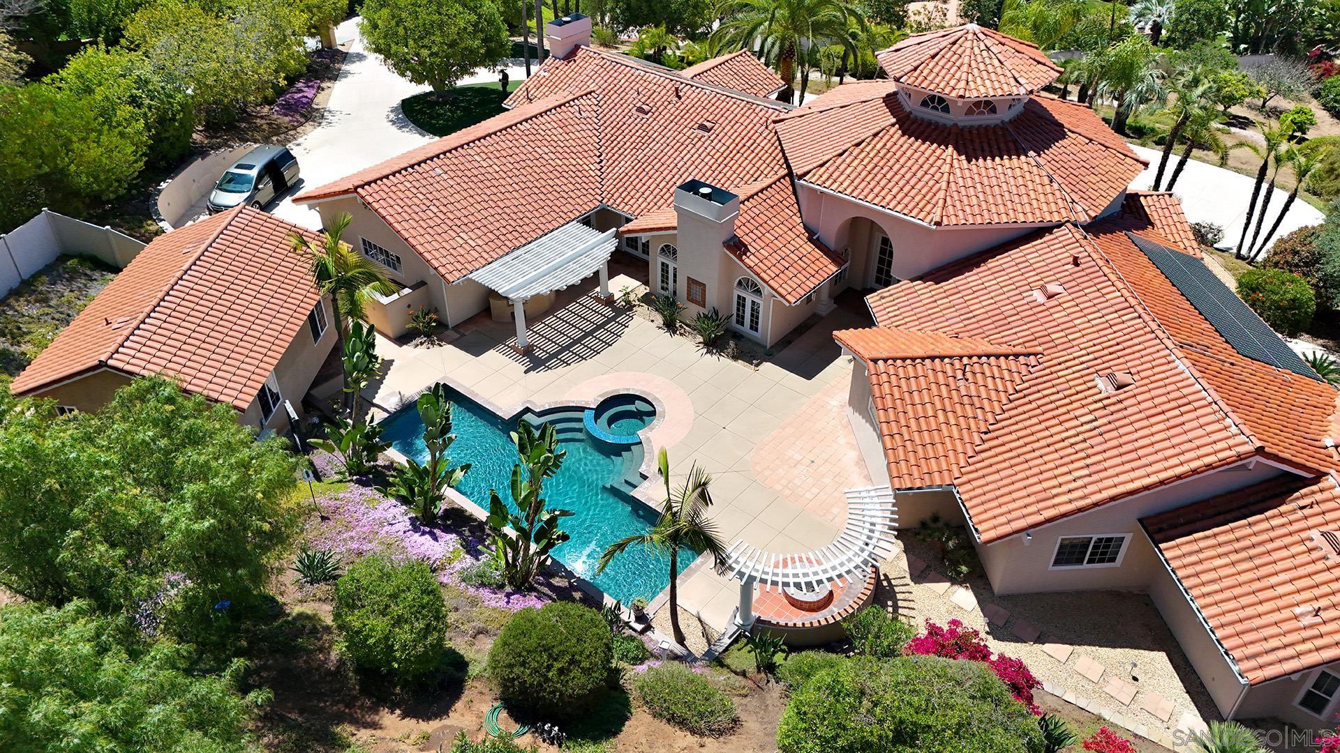 an aerial view of house with yard and swimming pool