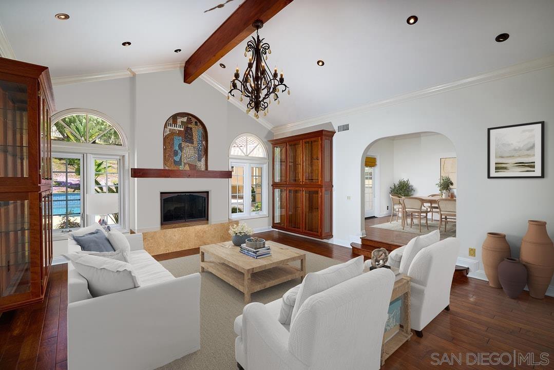 a living room with furniture a fireplace and a chandelier