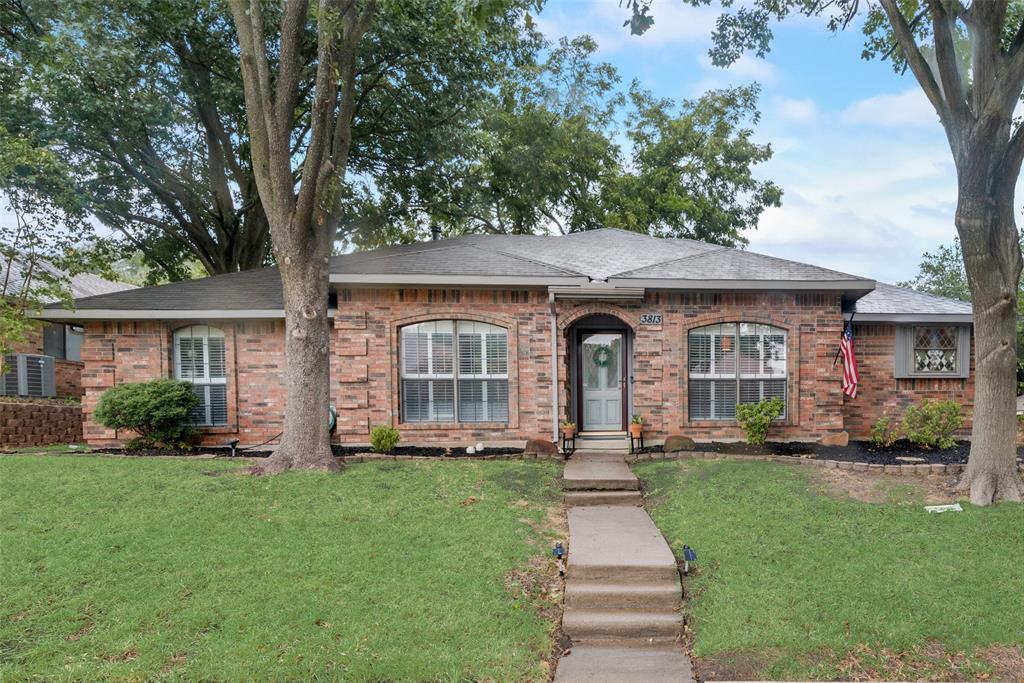 a front view of a house with a yard and trees