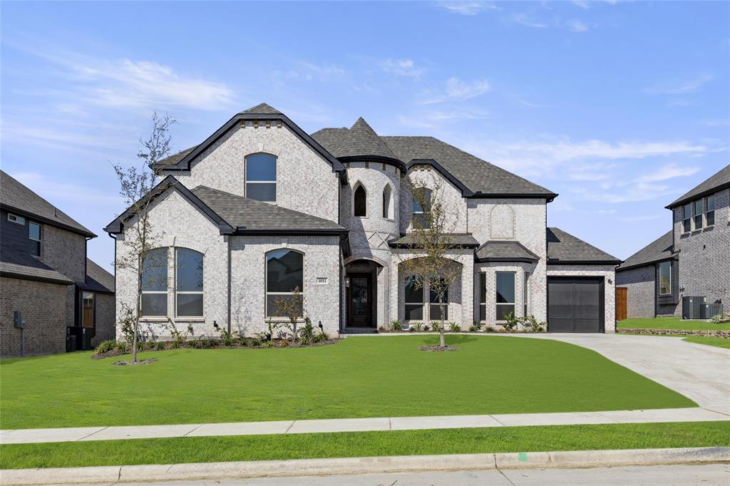 a front view of a house with a garden and yard