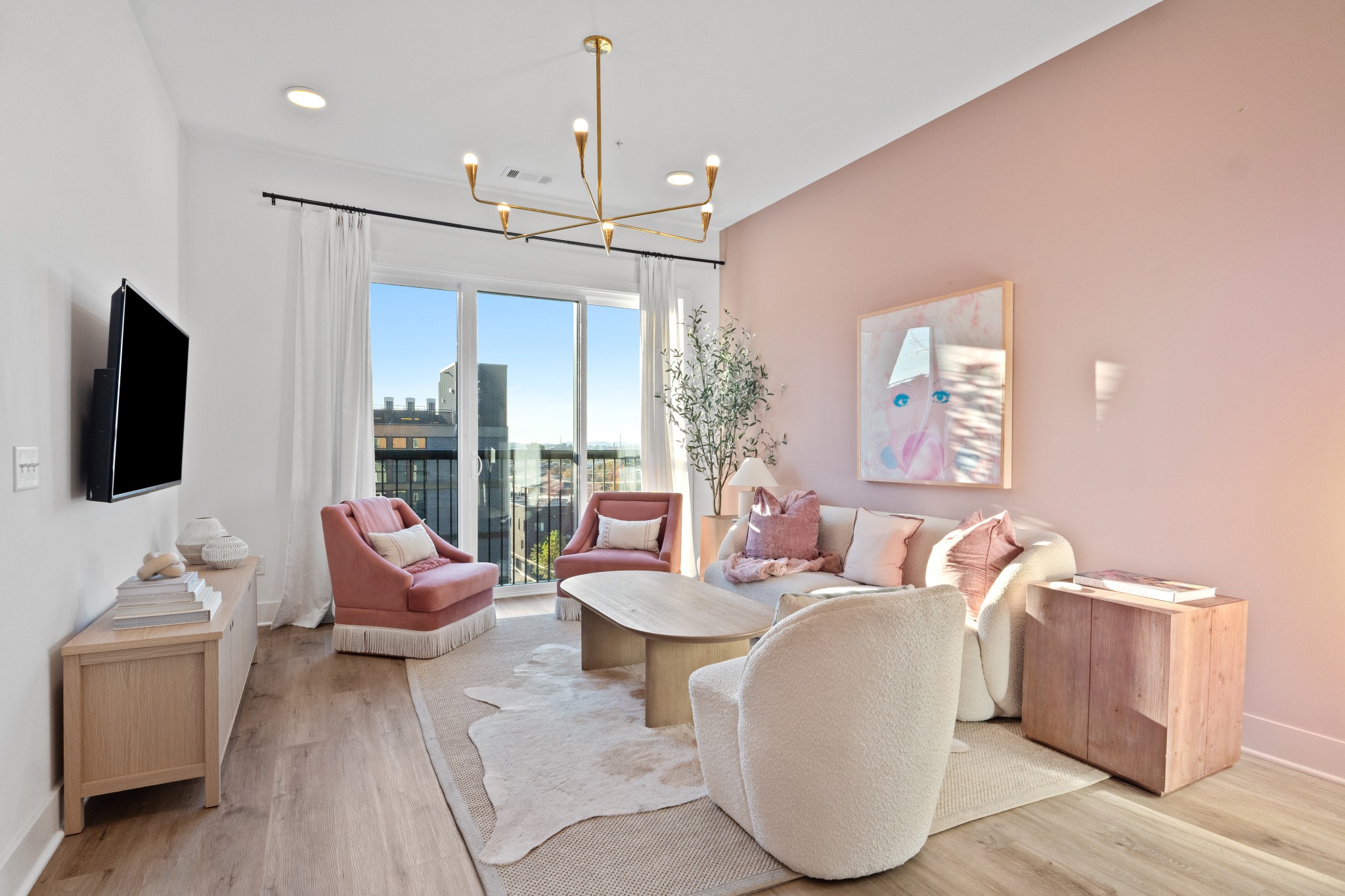 a living room with furniture a flat screen tv and a chandelier