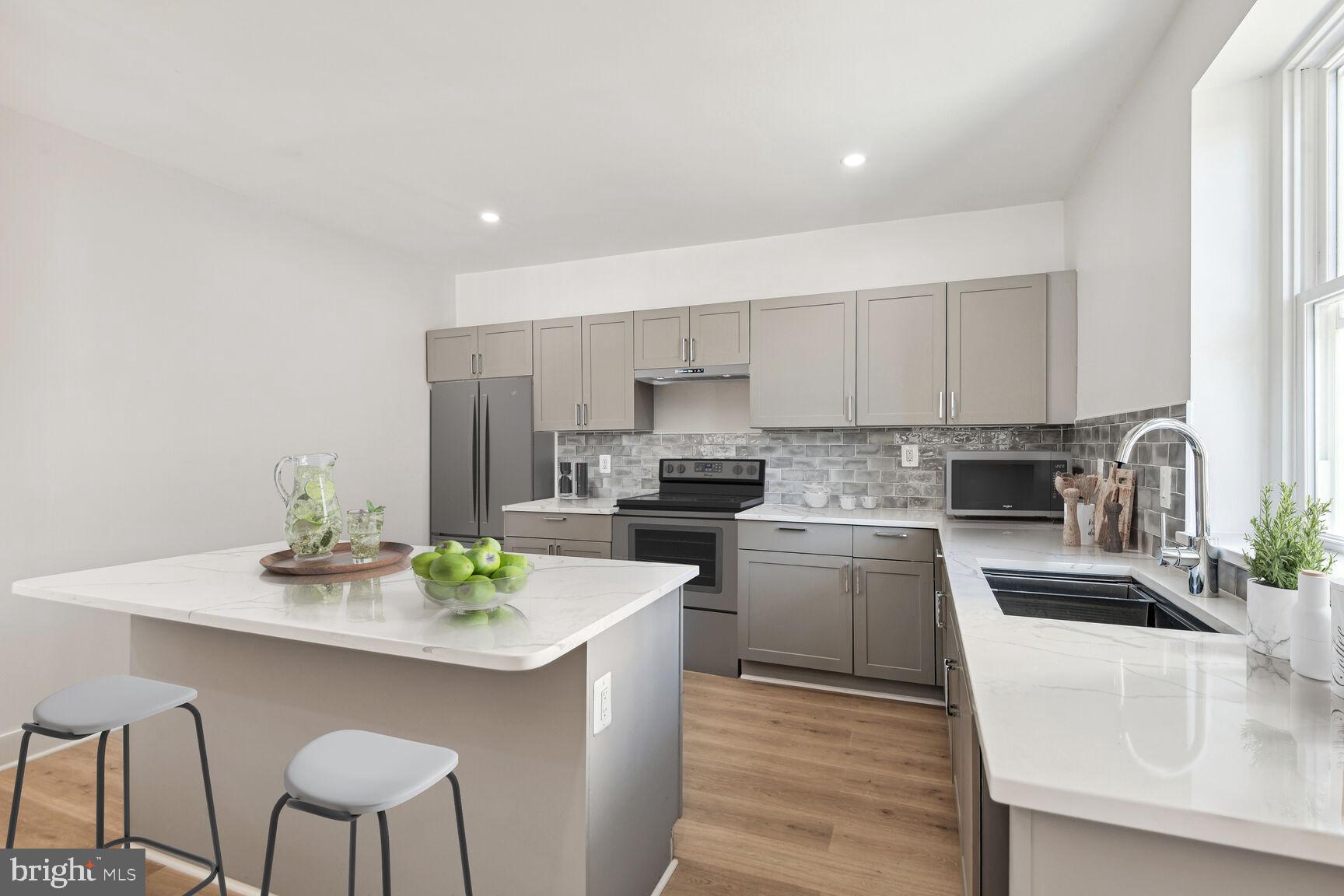 a kitchen with a sink white cabinets and stainless steel appliances