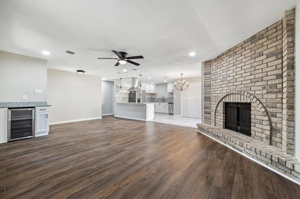 an empty room with wooden floor a fireplace and windows