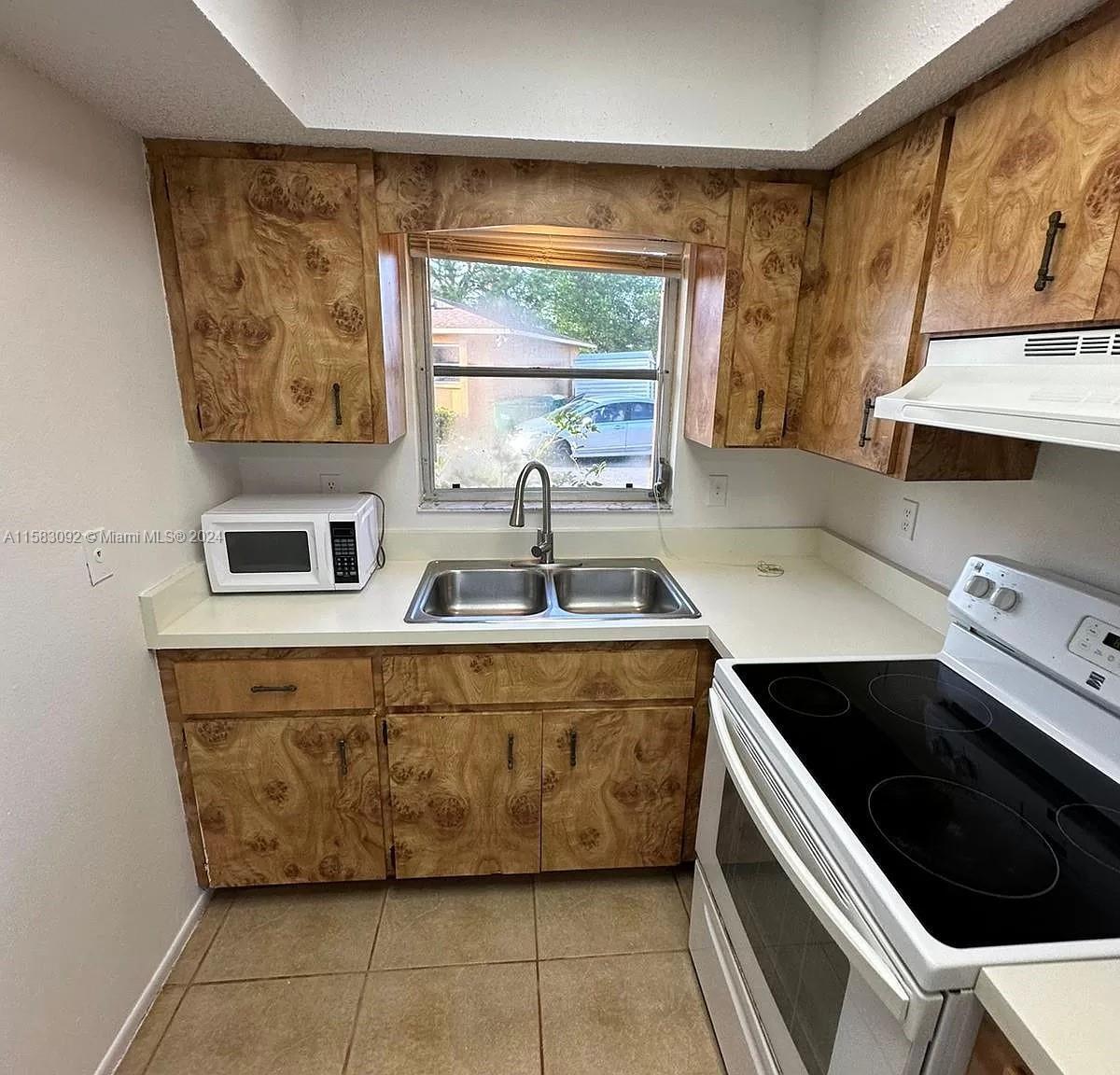 a kitchen with stainless steel appliances a sink a stove and a window