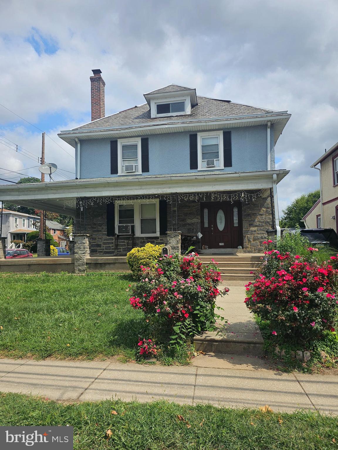 a front view of a house with a yard and a garden