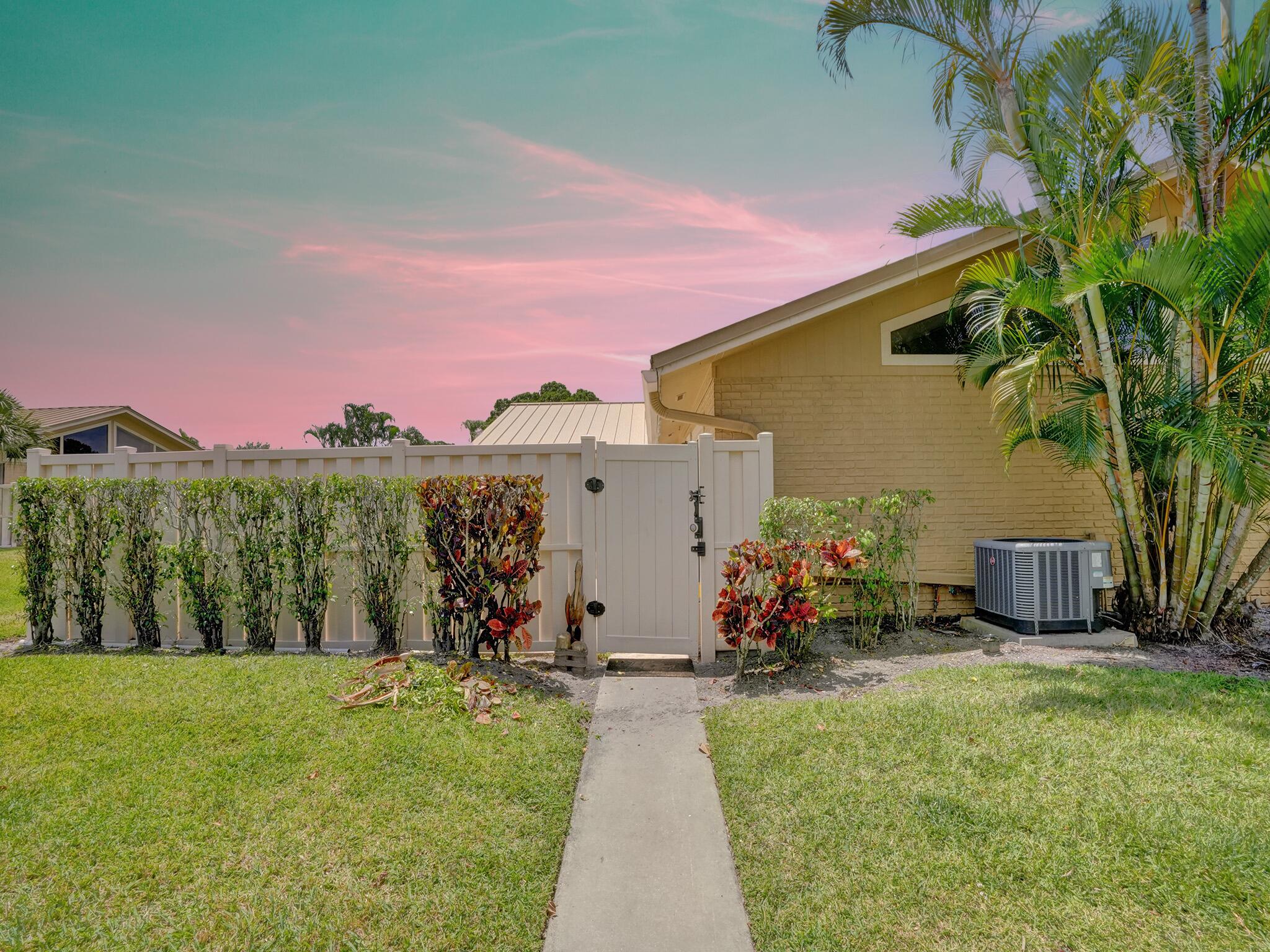 a view of a house with backyard and a sitting area