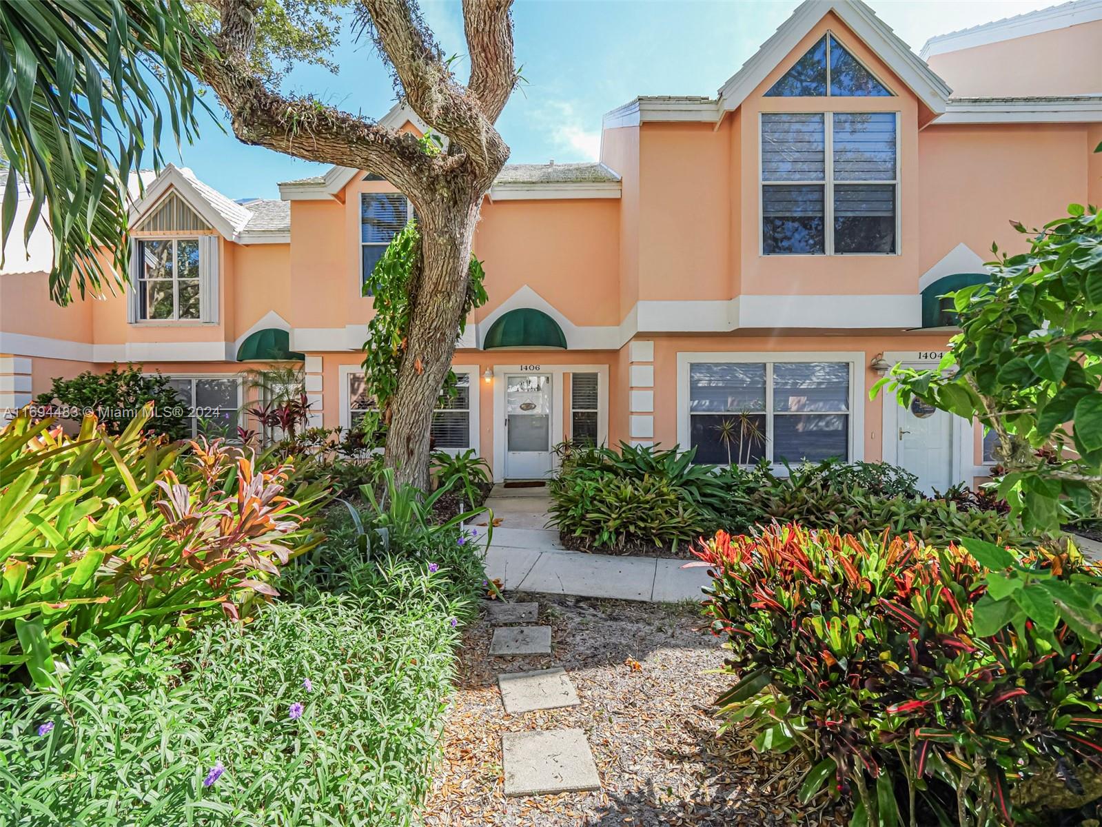 a front view of a house with a yard and potted plants