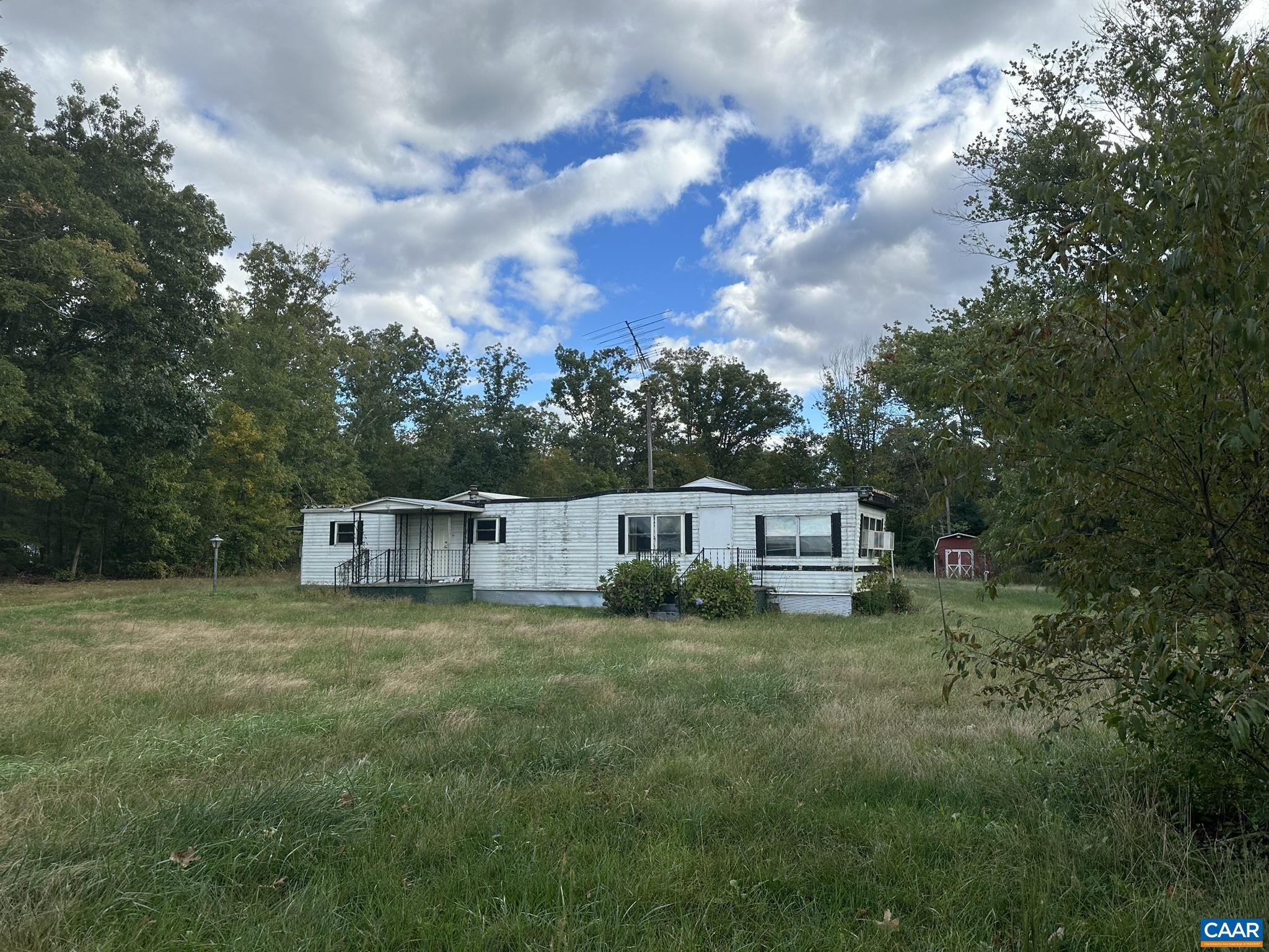 a view of a house with a big yard and large trees