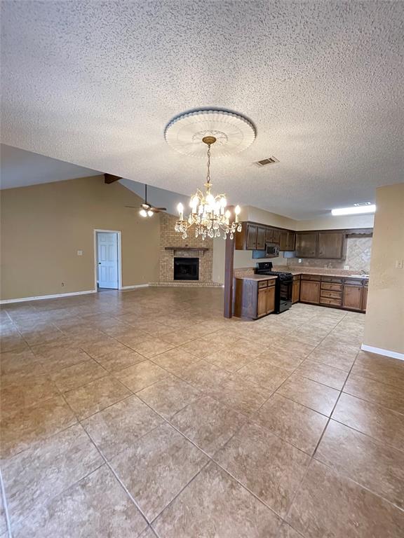 an empty room with kitchen and chandelier