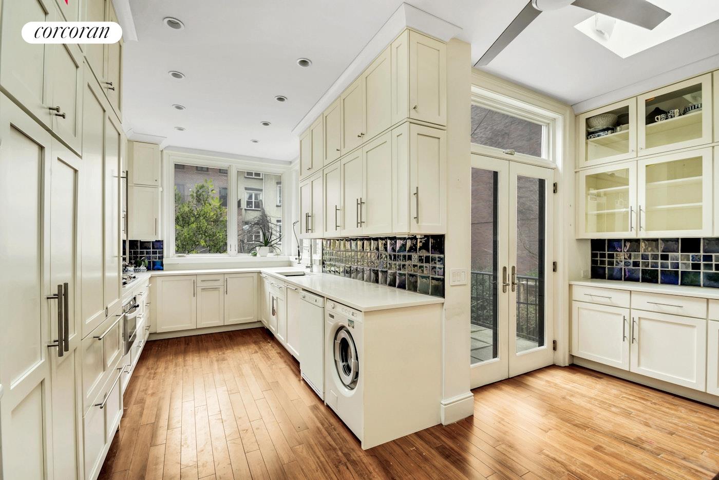 a kitchen with a refrigerator a sink and wooden floor