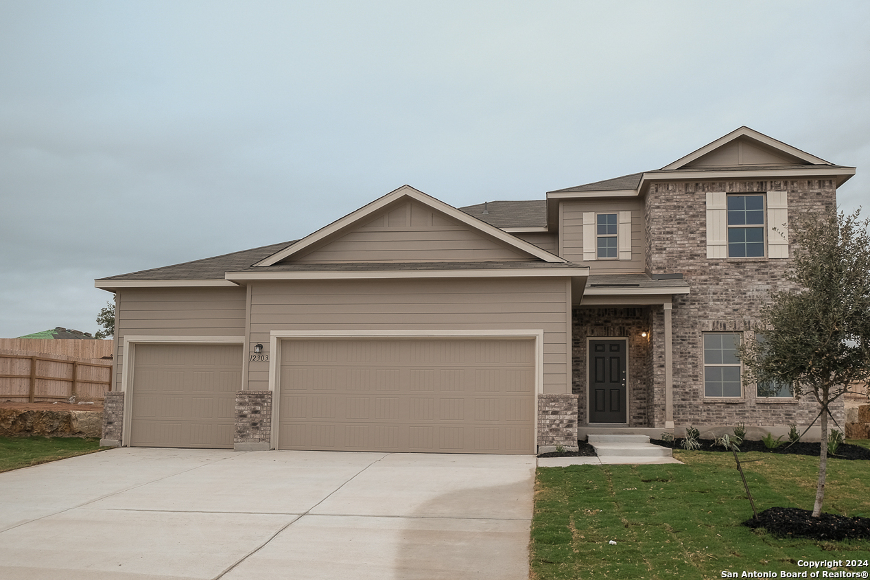 a front view of a house with a yard and garage