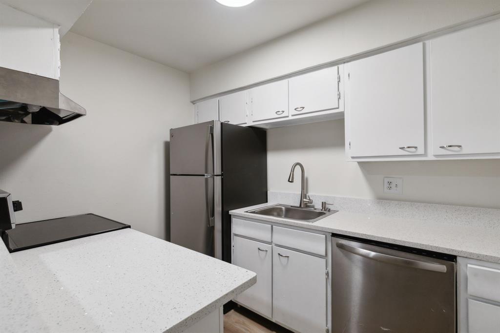 a kitchen with stainless steel appliances a refrigerator sink and cabinets