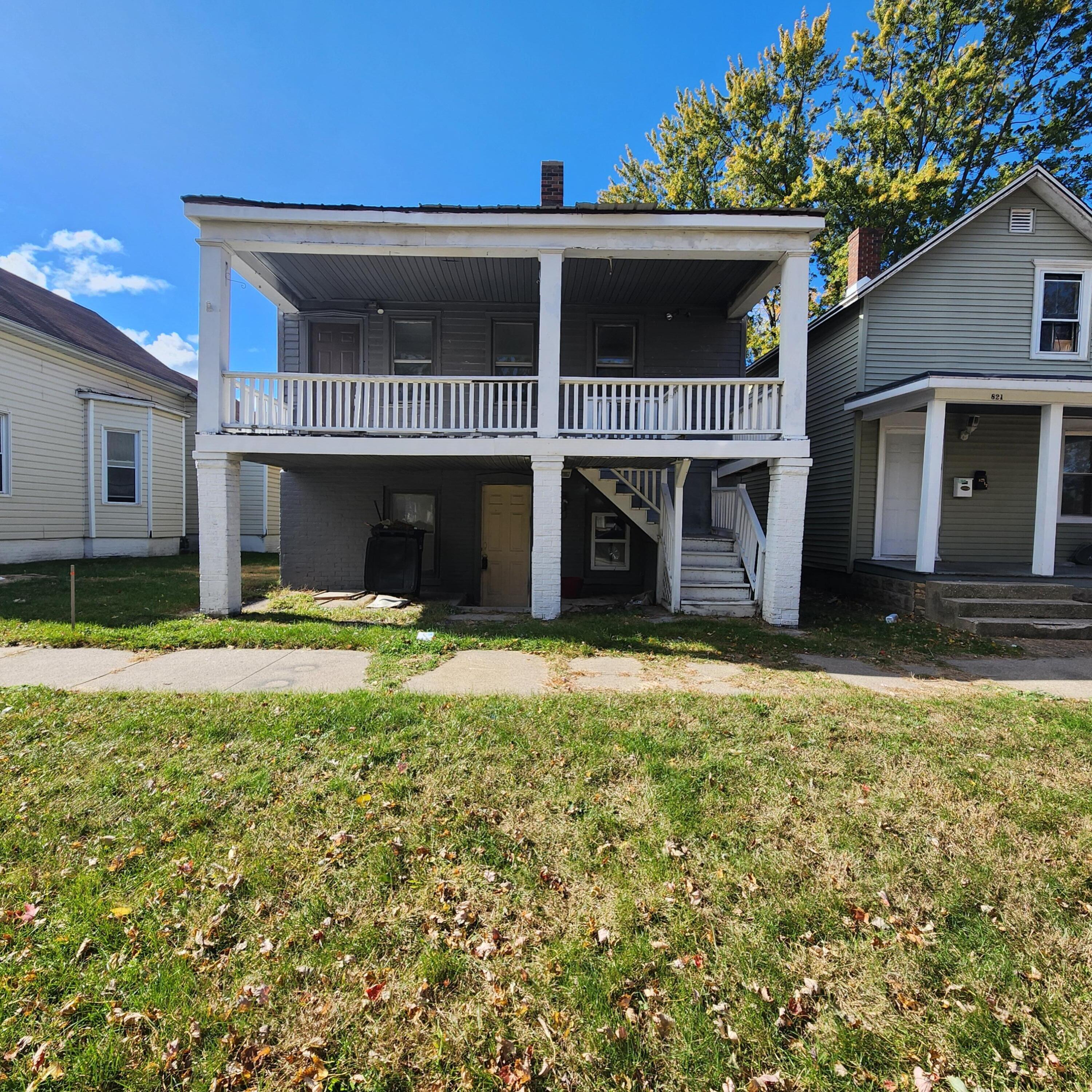 a view of a house with a yard and porch