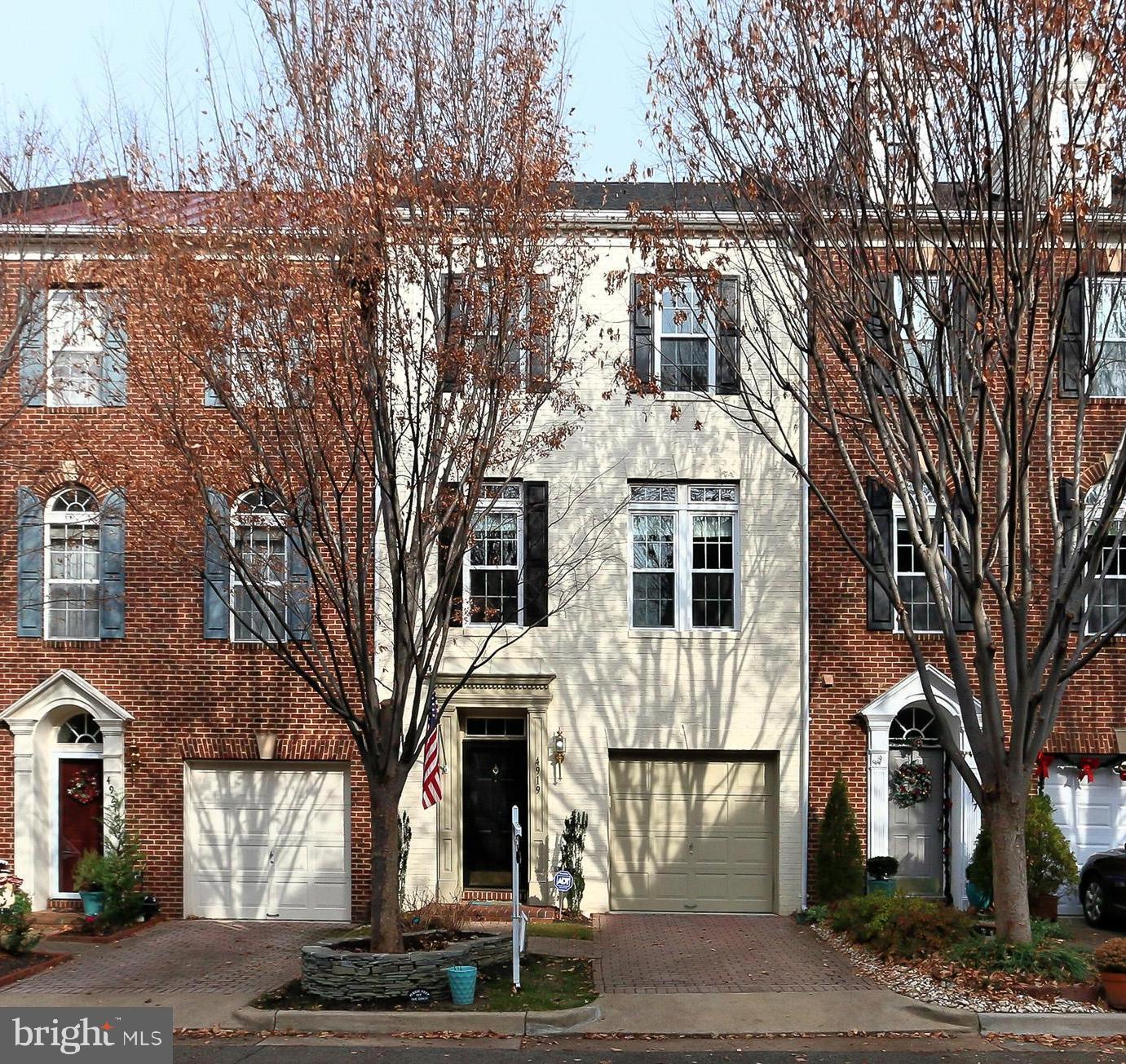 a view of a white house with a large tree