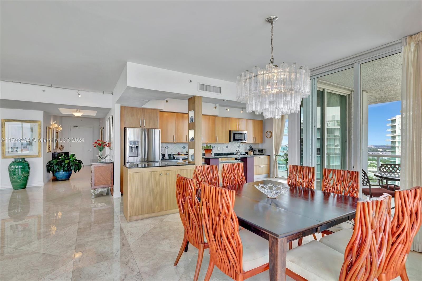 a view of a dining room and livingroom with furniture large windows a chandelier and chandelier