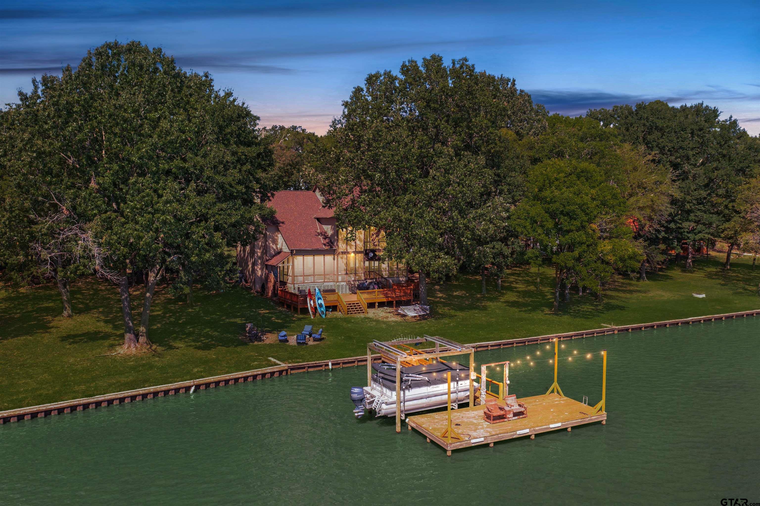 an aerial view of a house with swimming pool a yard and a fountain