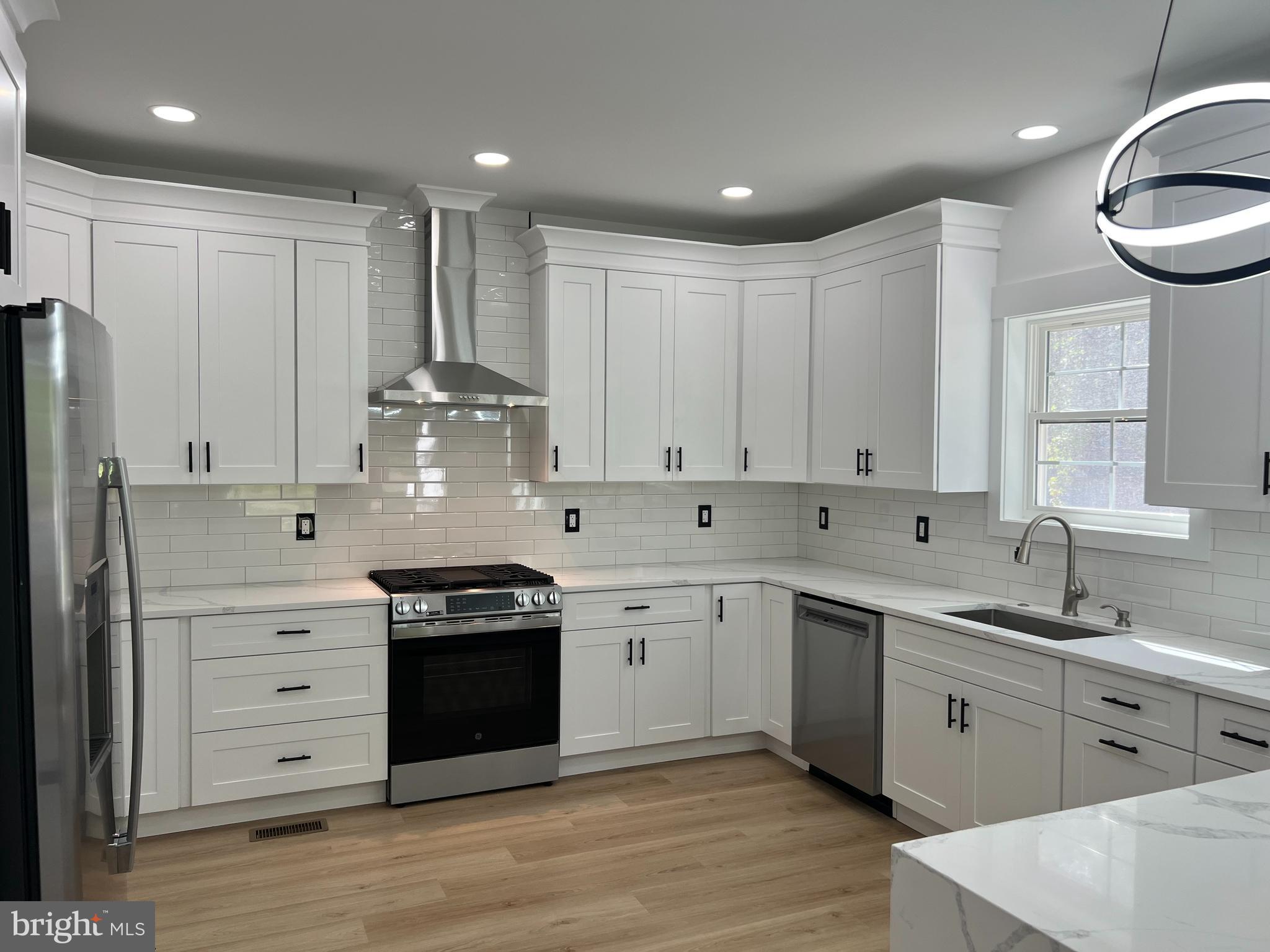 a kitchen with a white wooden cabinets and white appliances