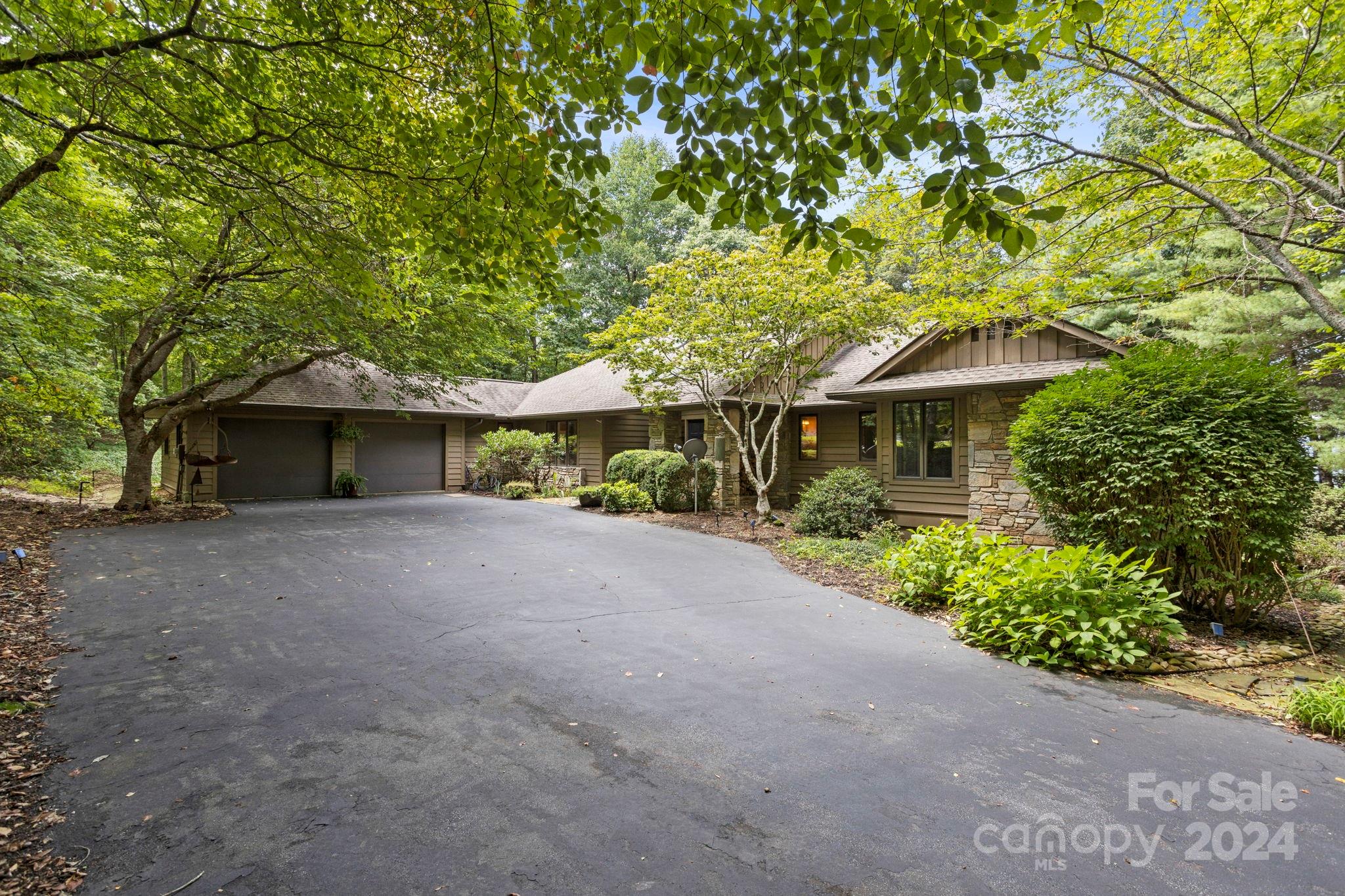 a front view of a house with a garden and tree