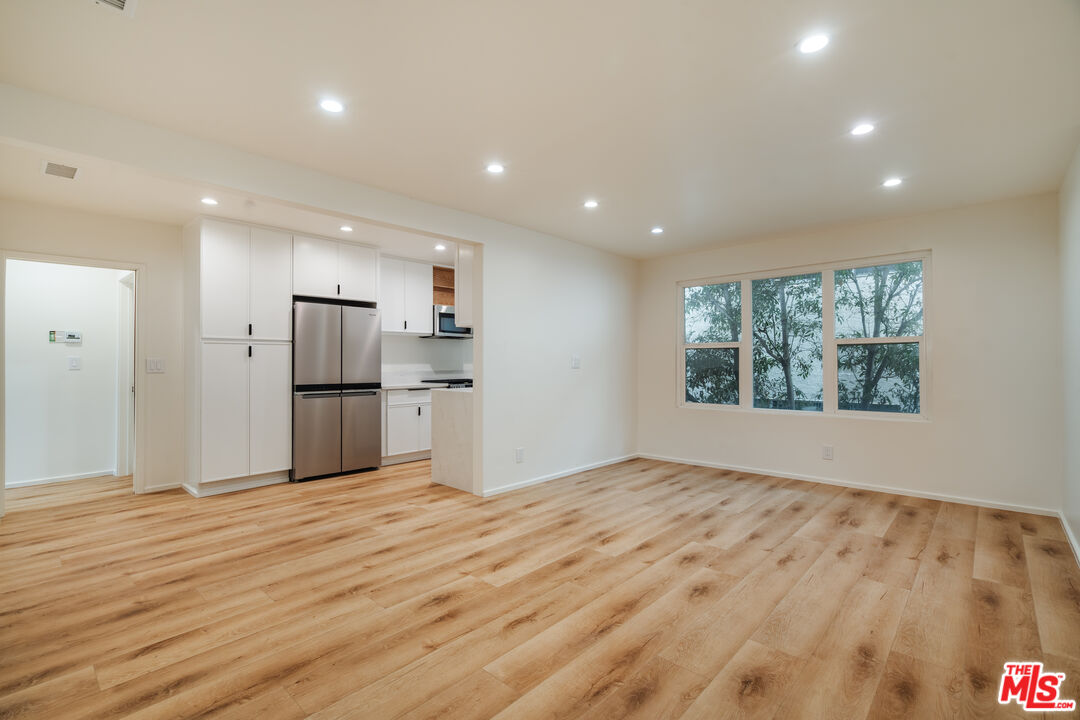 a view of empty room with wooden floor and window