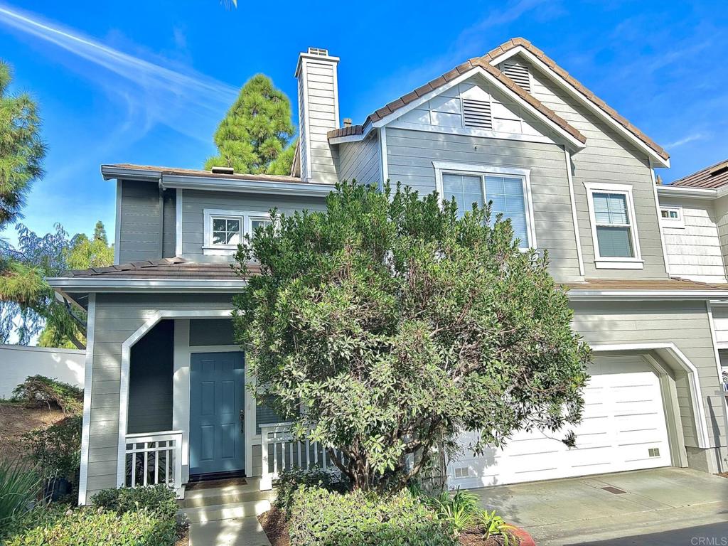 a view of a house with potted plants and a tree