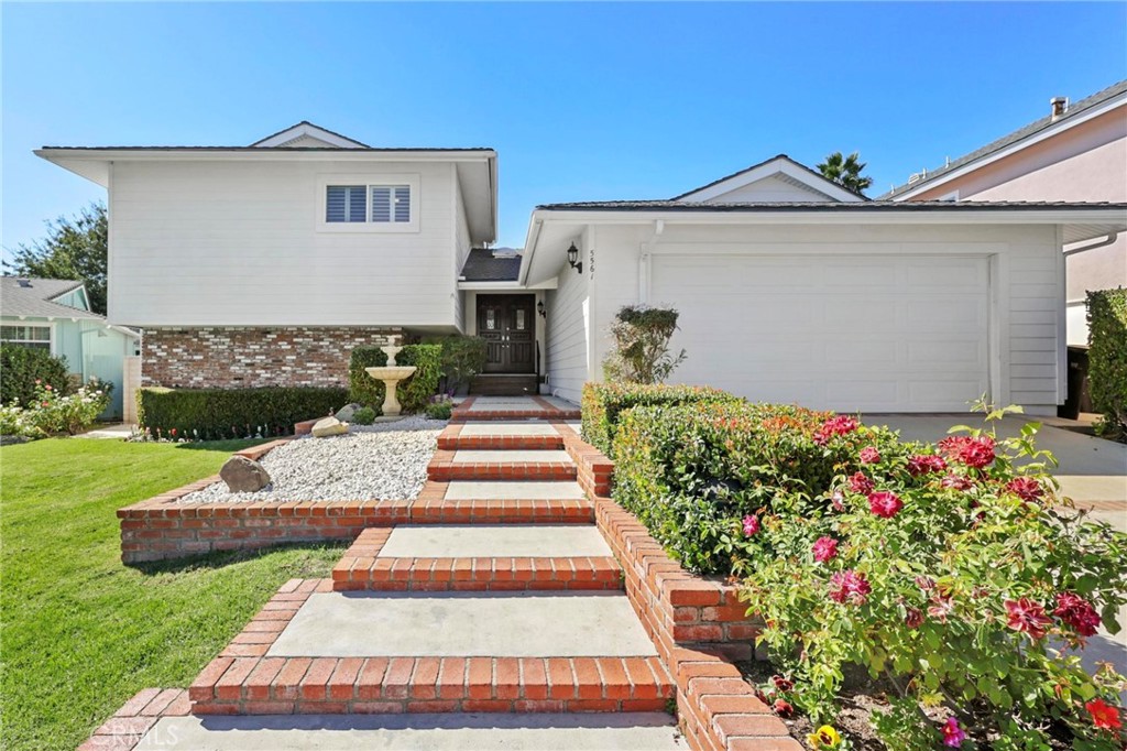 a front view of a house with a yard and potted plants