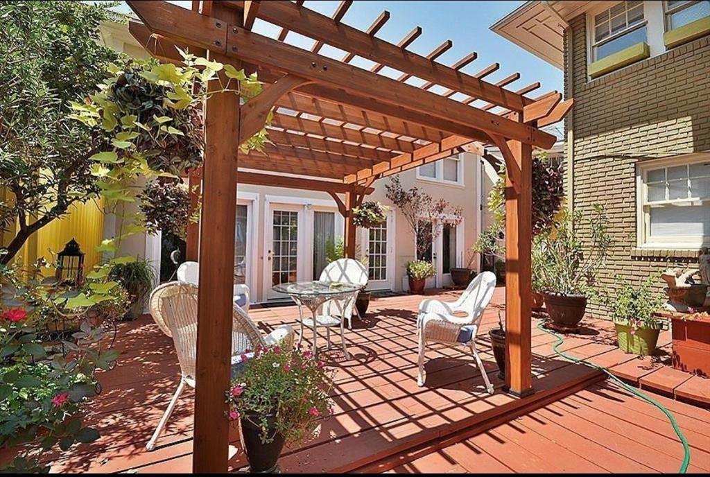 a view of a patio with table and chairs potted plants and large tree