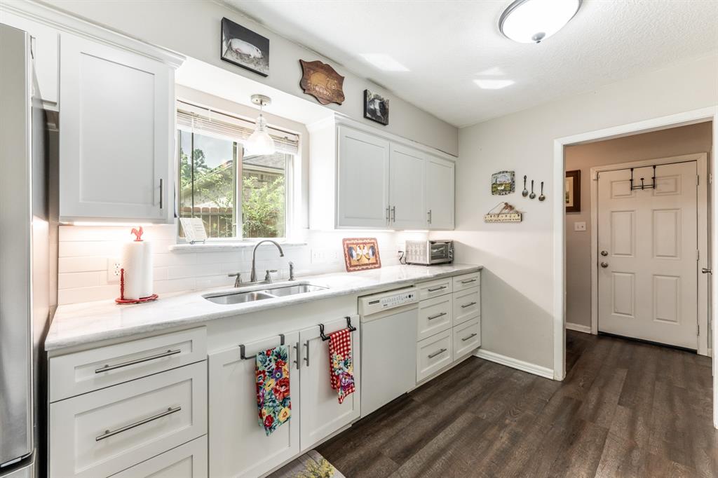 a kitchen with granite countertop cabinets a sink a window and stainless steel appliances