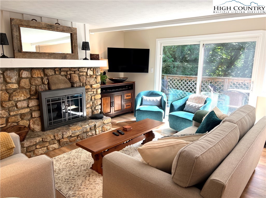 a living room with furniture a fireplace and a flat screen tv