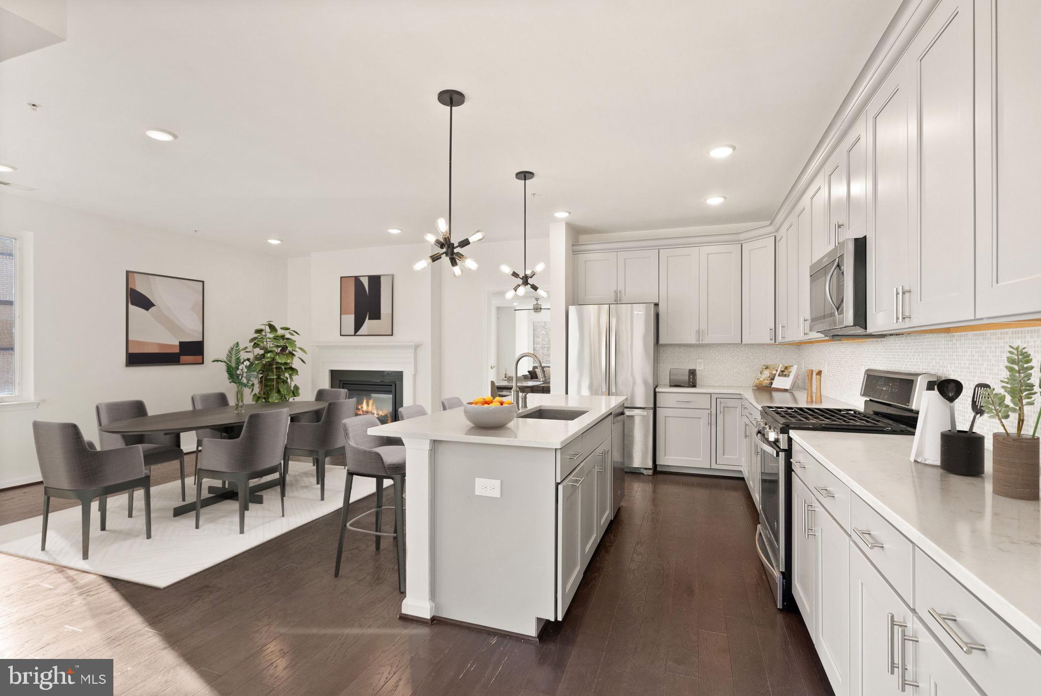 a view of a kitchen with kitchen island a stove a workspace and a living room view