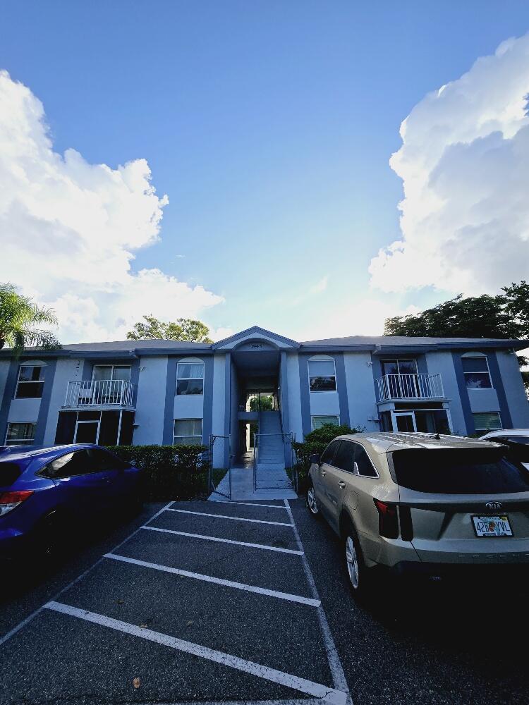 a front view of residential houses with cars parked on road