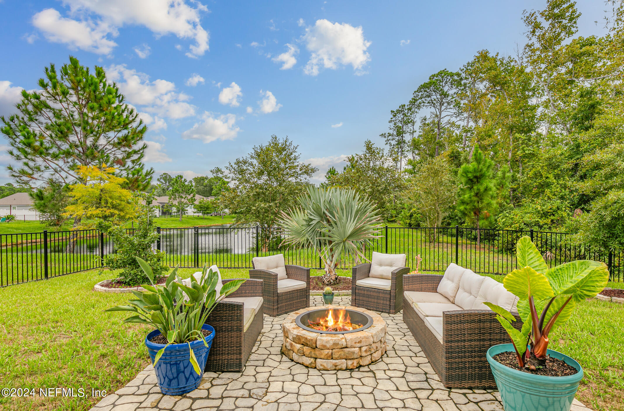 a view of a backyard with plants and chairs