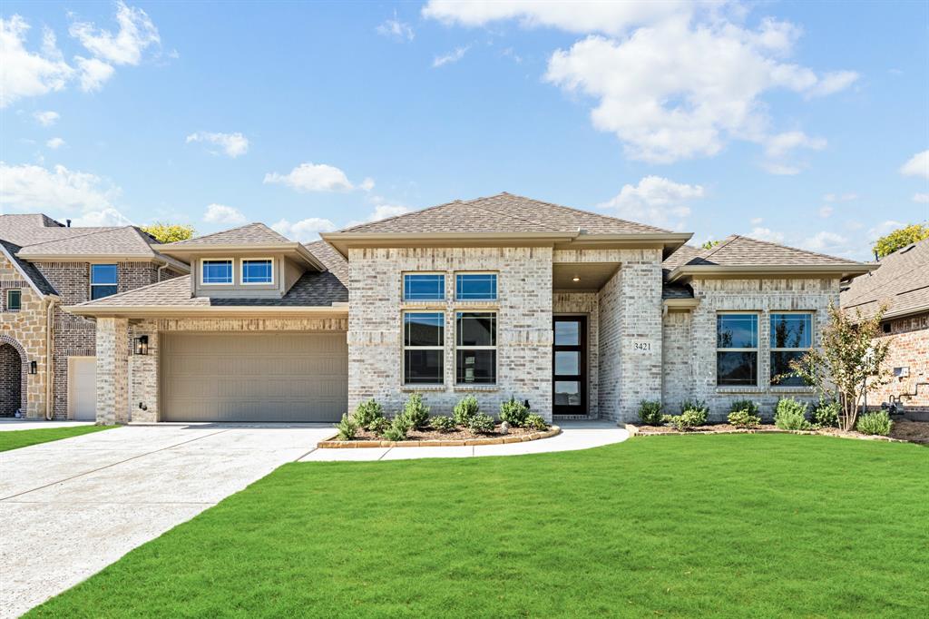 a front view of a house with a garden and yard