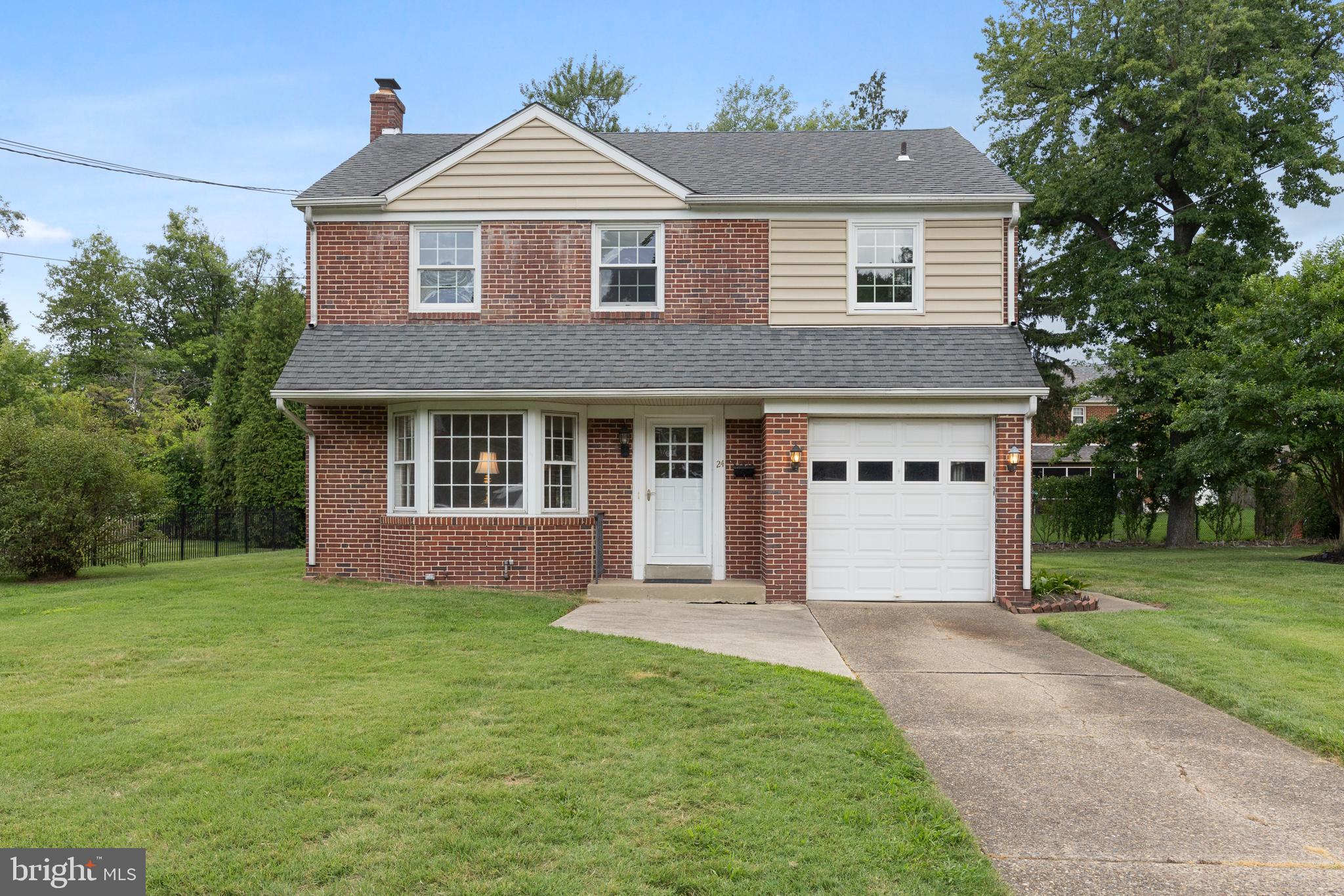 a front view of a house with a yard and trees