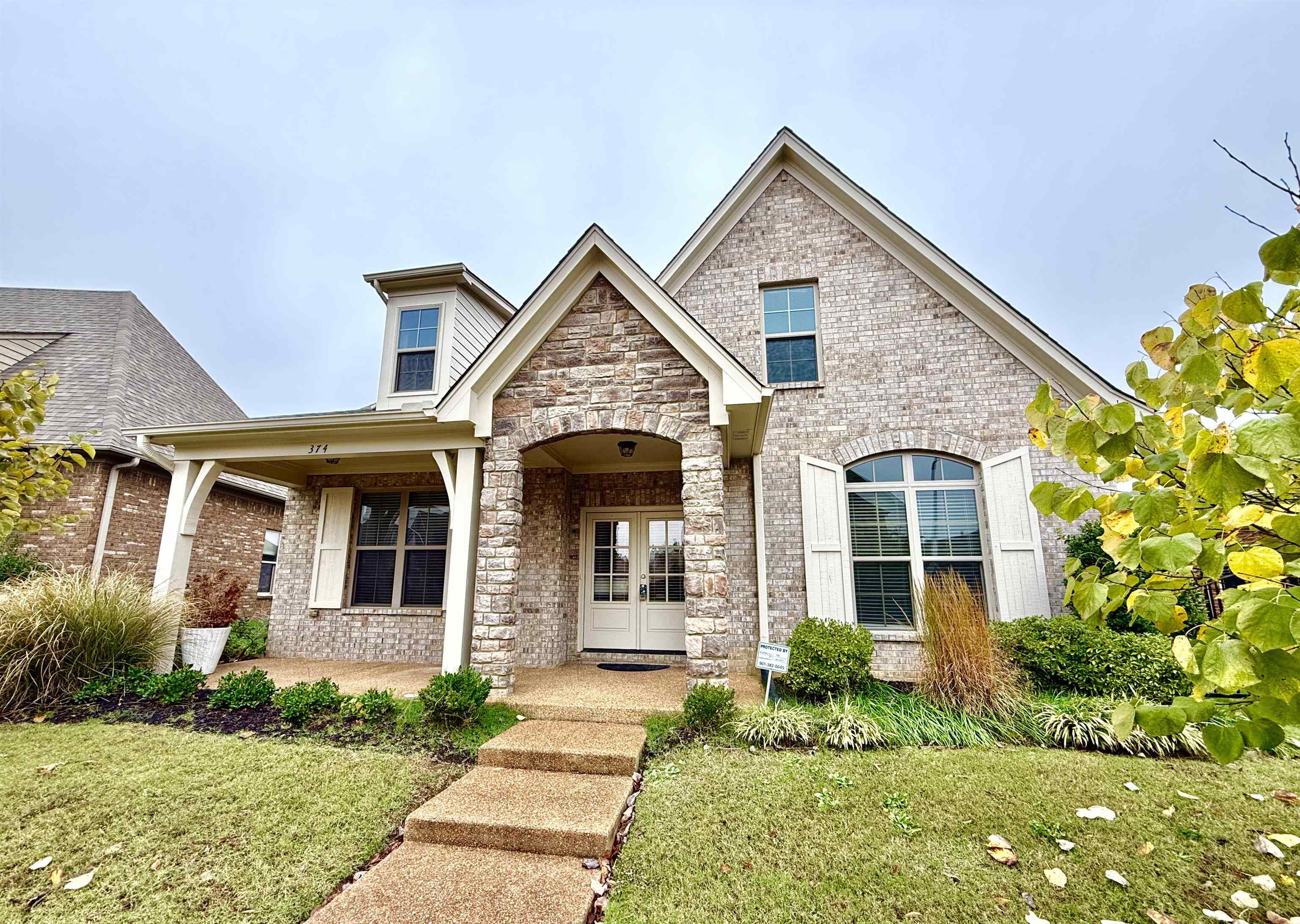 View of front of property with covered porch and a front lawn