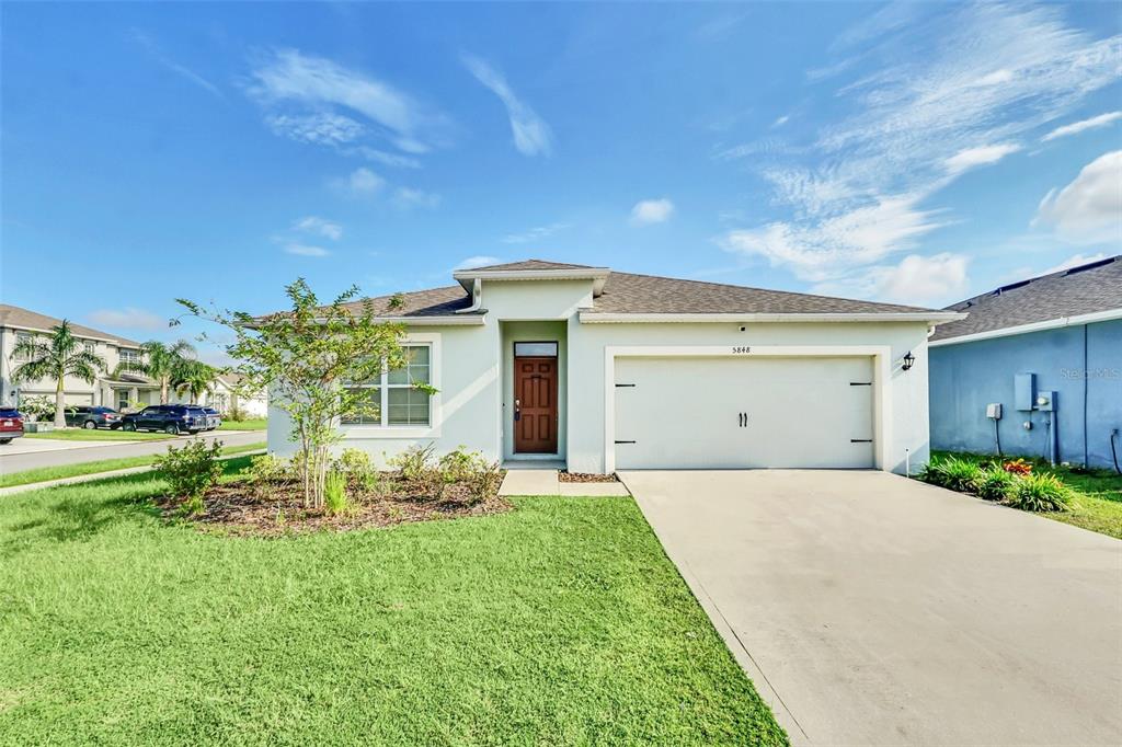 a front view of a house with a yard and garage