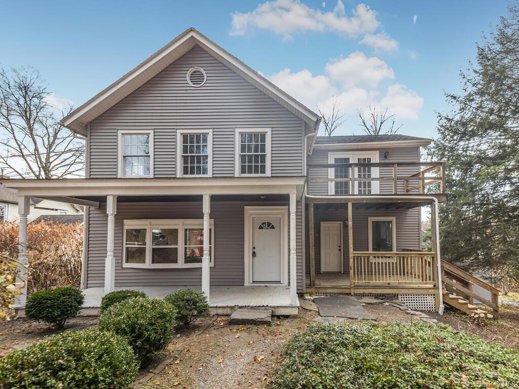 View of front property featuring covered porch and a balcony