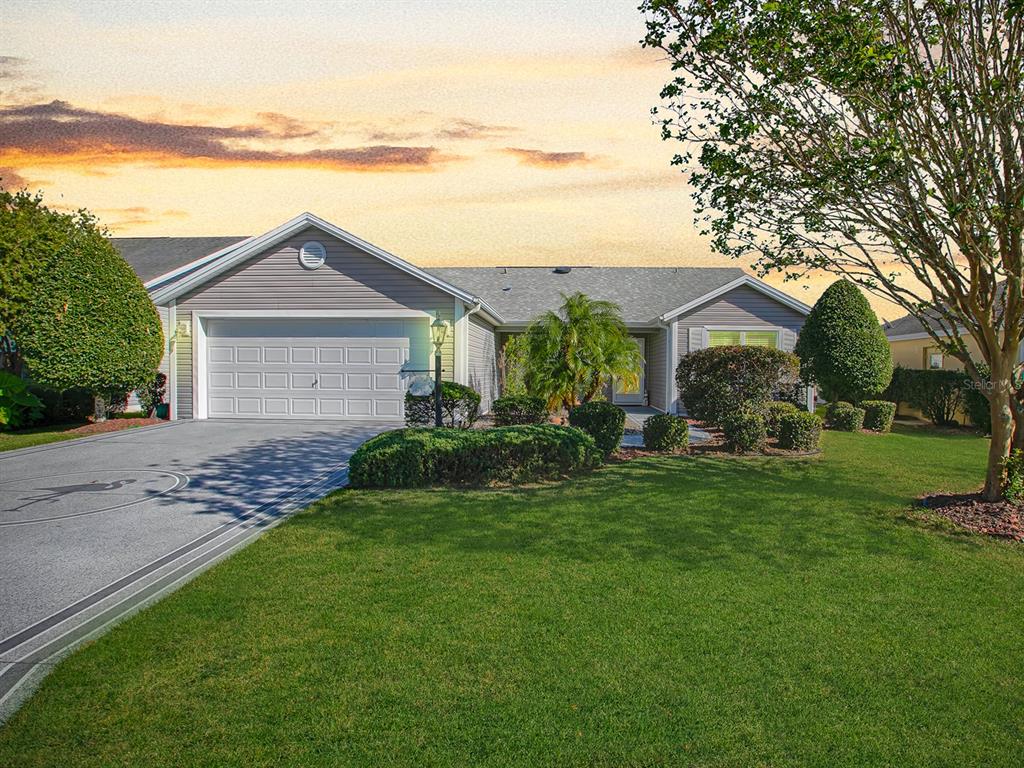 a front view of a house with a garden and yard