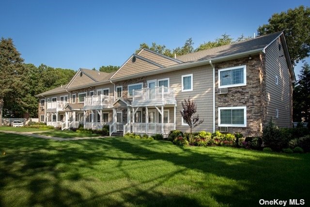 a front view of a house with a garden and trees