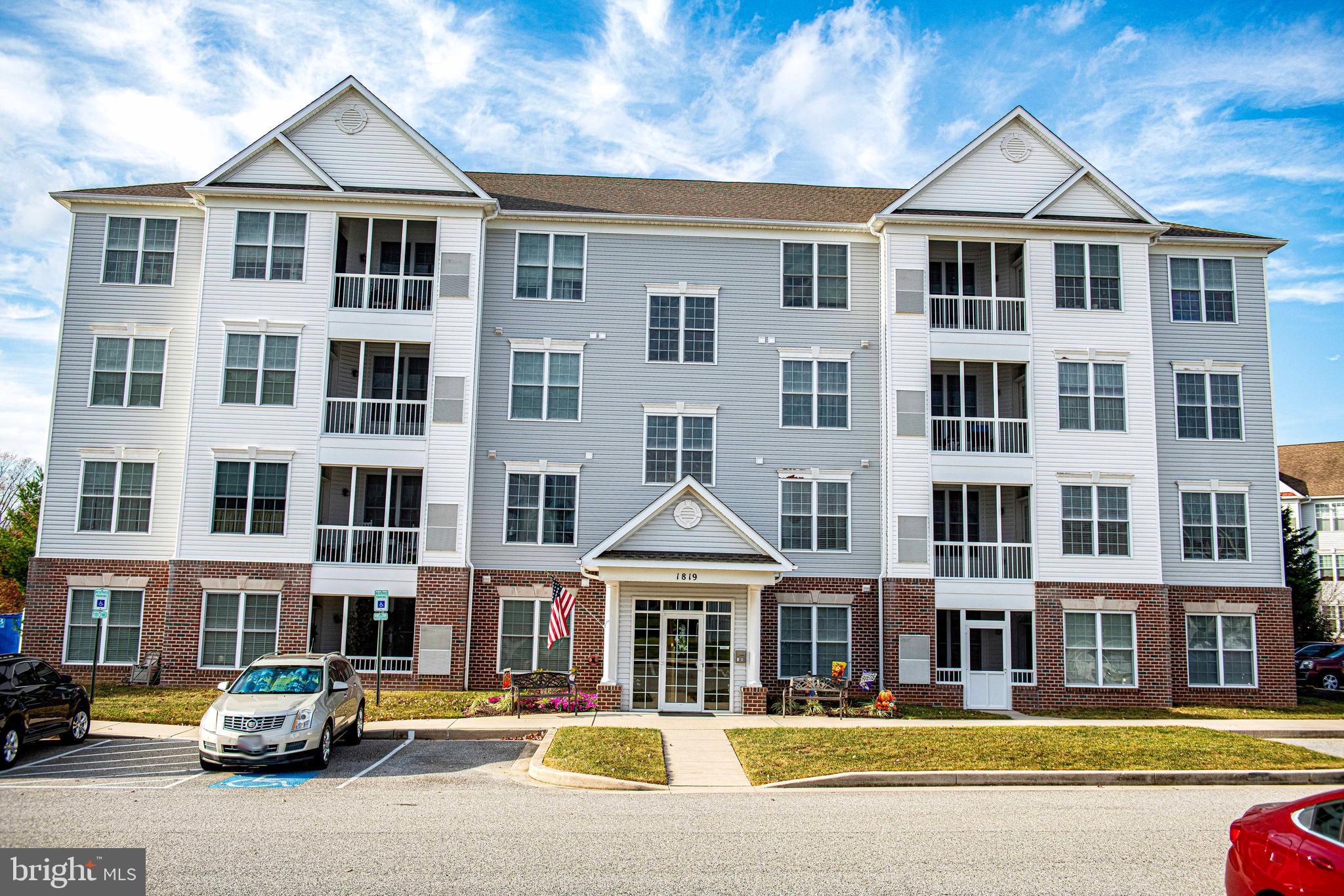 a front view of building with cars parked