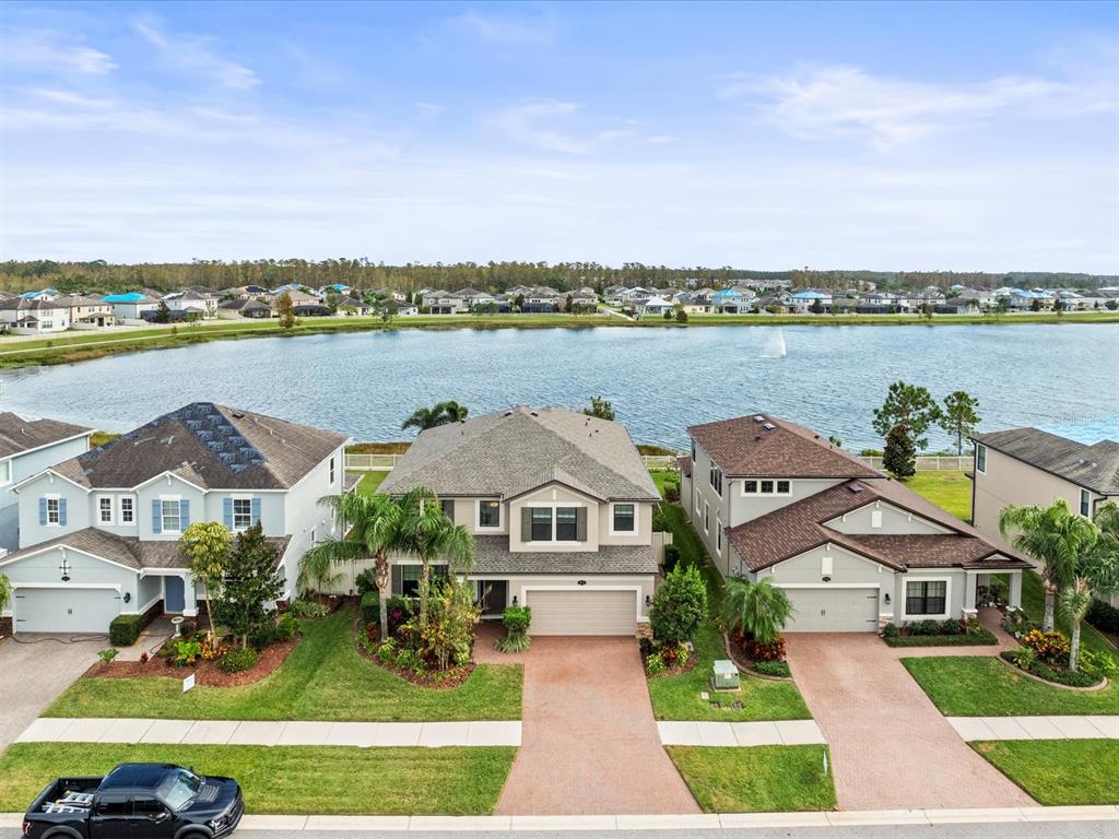 an aerial view of a house with a garden and lake view