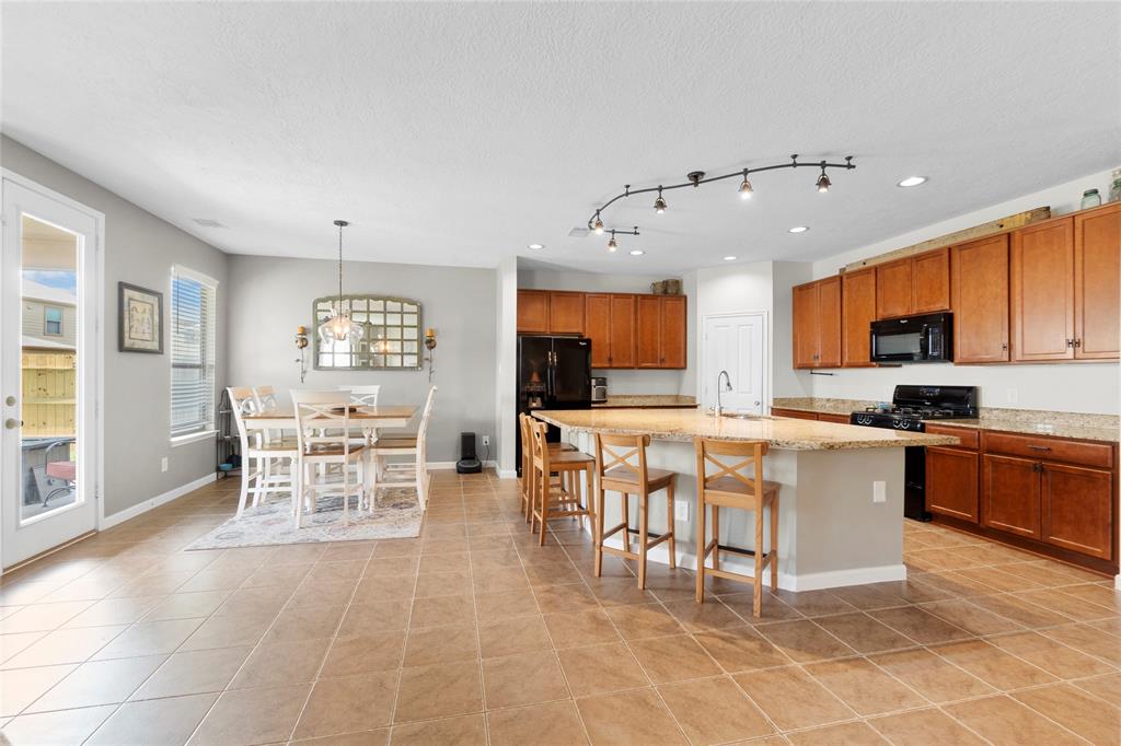 a large kitchen with kitchen island stainless steel appliances a stove a dining table and chairs