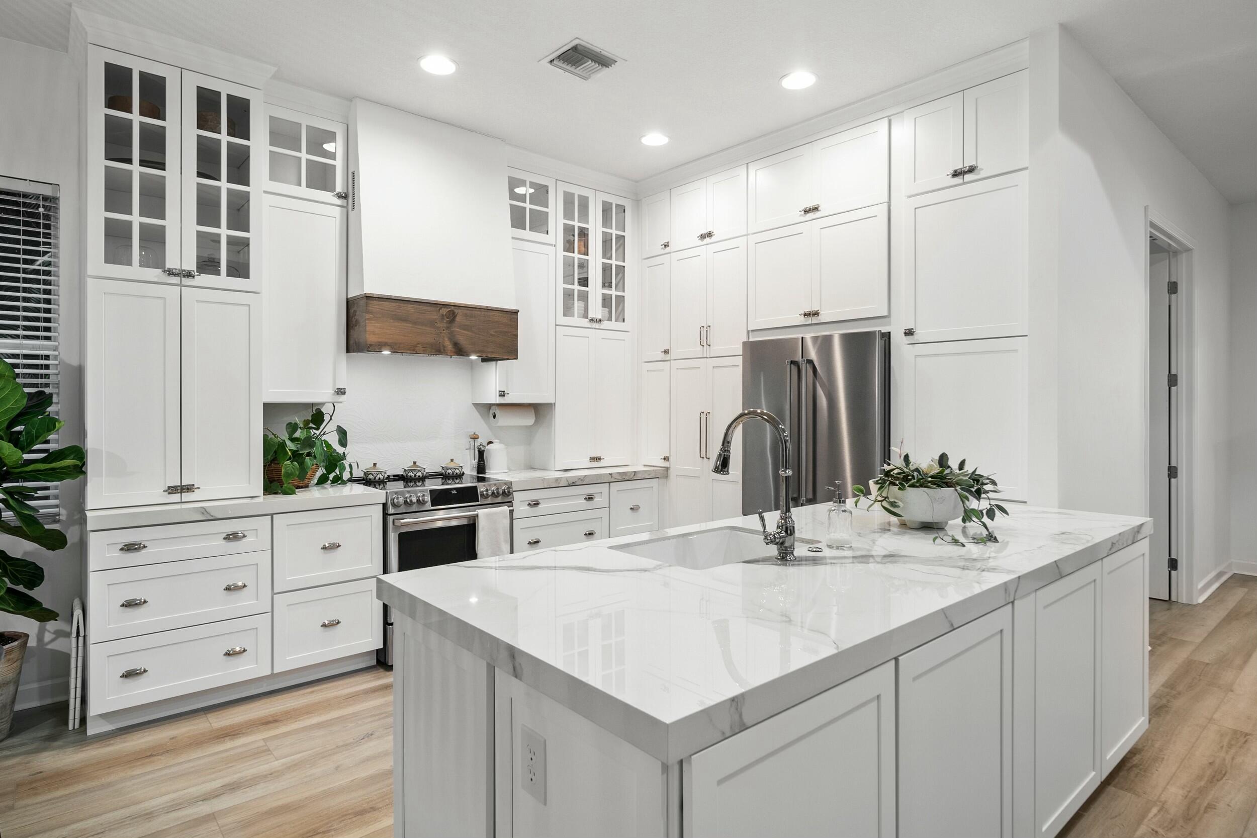 a kitchen with stainless steel appliances kitchen island granite countertop a sink stove and refrigerator