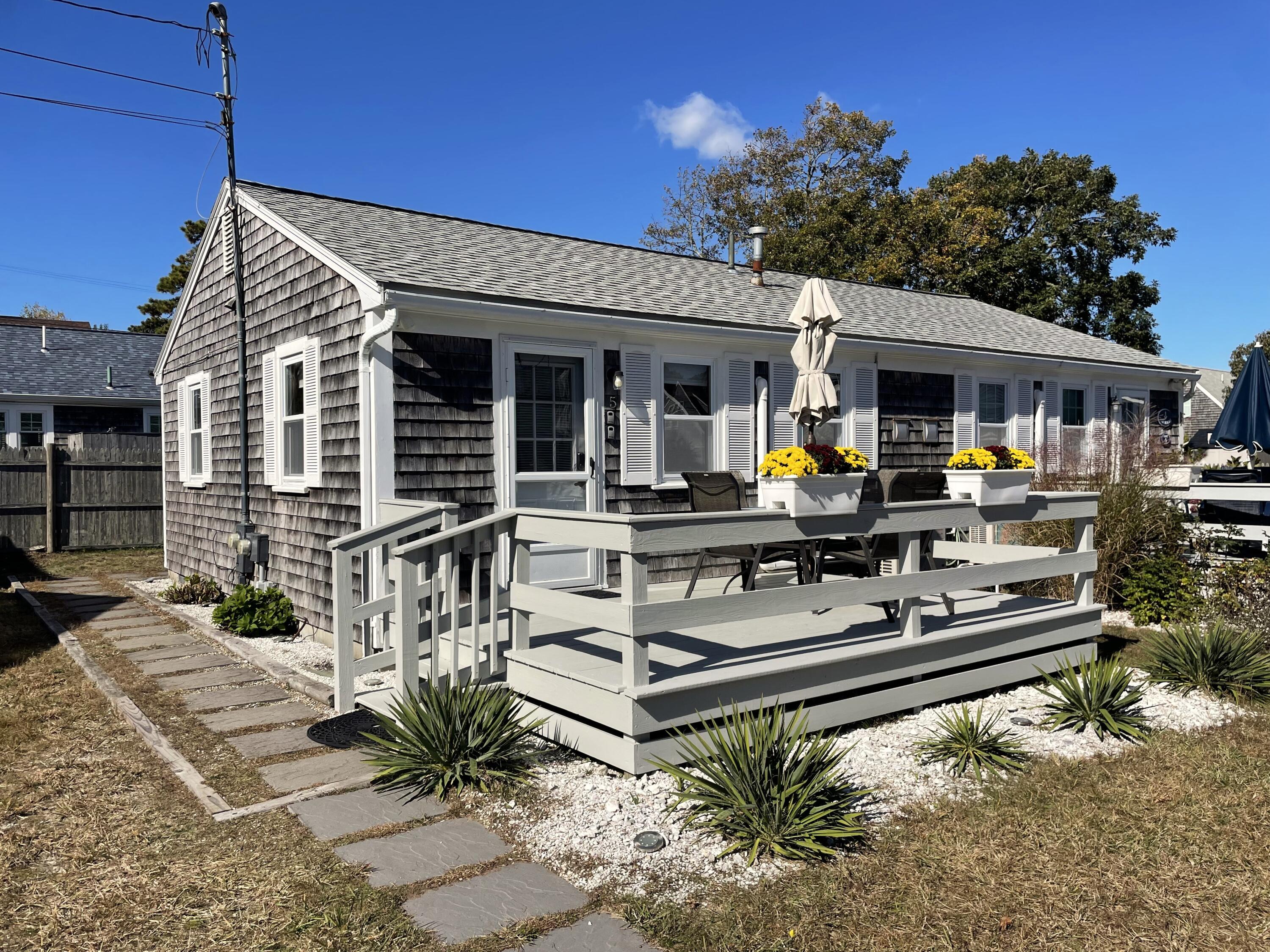 a view of a house with wooden deck and furniture